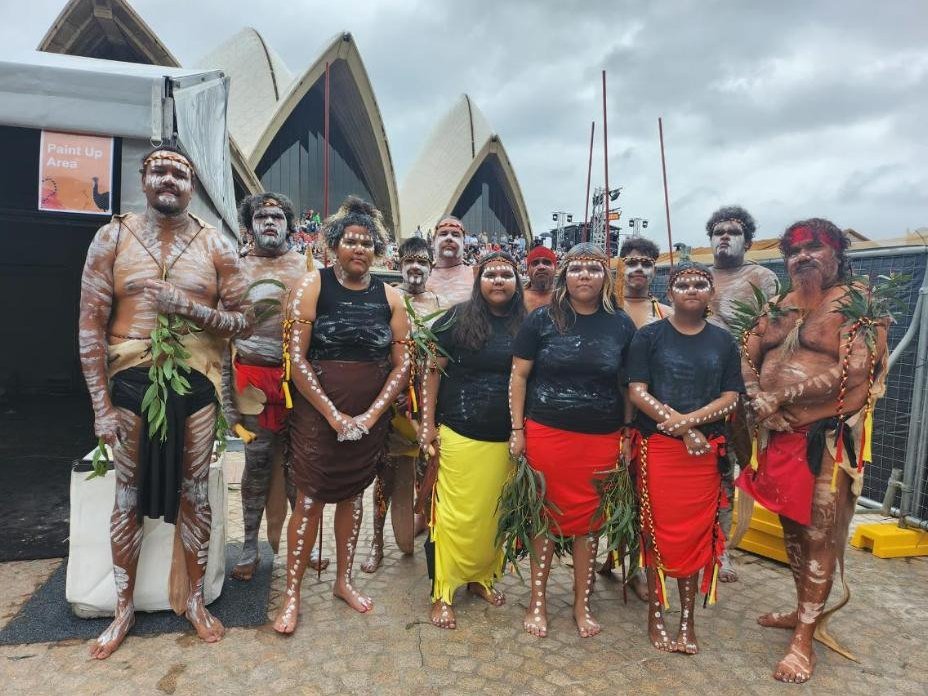 The Ngadju Dancers troupe painted up together outside the Sydney Opera House